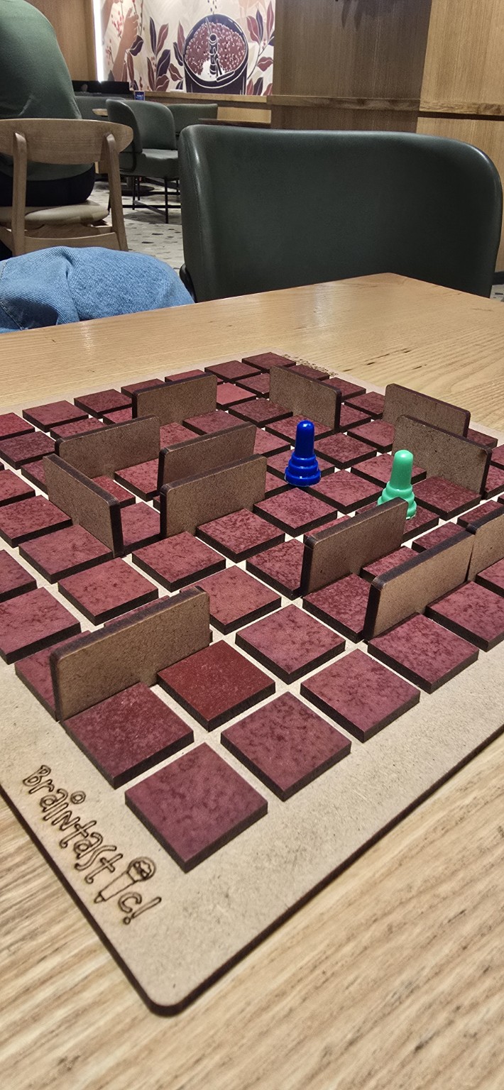 Two colourful player pieces navigating a handcrafted maze board game